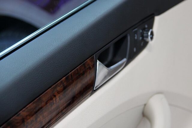 2012 Volkswagen Passat interior door panel wood trim and window controls detail
