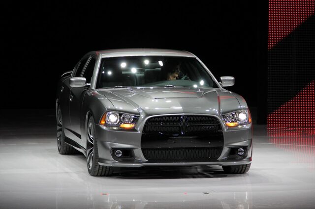 2012 Dodge Charger SRT-8, straight-on front view with headlights on in dark arena