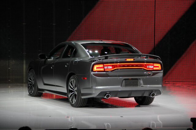 2012 Dodge Charger SRT-8, driver-side rear three-quarter view with taillights on