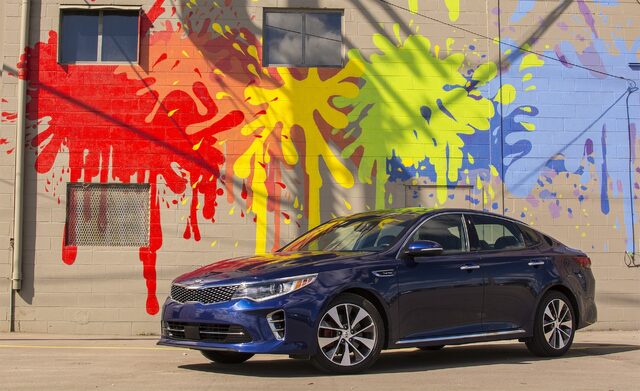 2016 Kia Optima SXL Front Three-Quarter View Parked by Graffiti Mural Wall in Sunlight