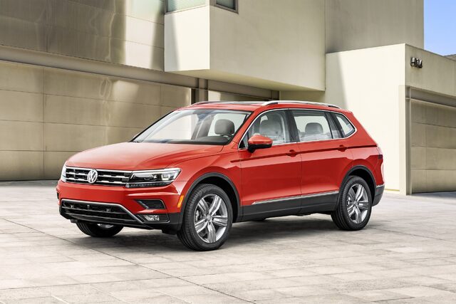 2018 Volkswagen Tiguan SE front three-quarter view in red at architectural setting