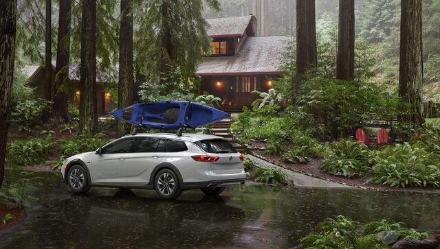 2018 Buick Regal TourX white rear three-quarter view with kayak on roof rack