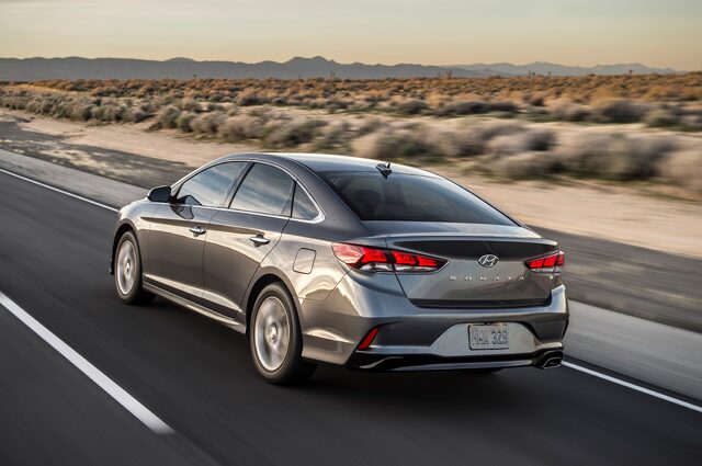 2018 Hyundai Sonata Sport gray sedan rear three-quarter view in motion on desert highway
