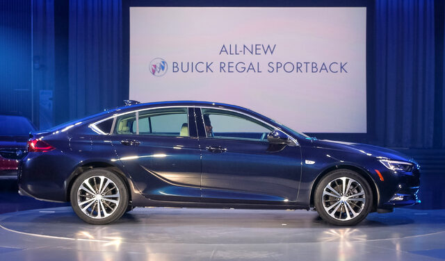 2018 Buick Regal Sportback blue side profile at live reveal with signage