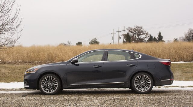 2017 Kia Cadenza Limited Driver Side Profile on Gravel Road with Winter Grass and Snow
