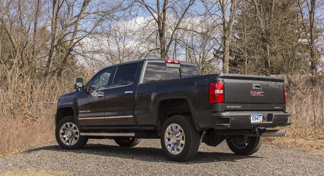 2017 GMC Sierra Denali 2500HD rear three-quarter view on gravel road