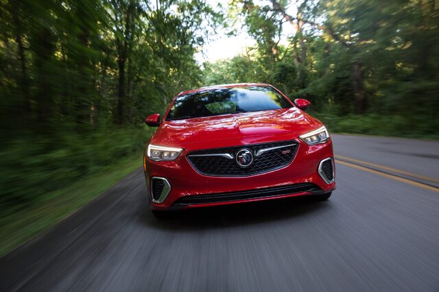 2018 Buick Regal GS, front view in motion on a tree-lined road