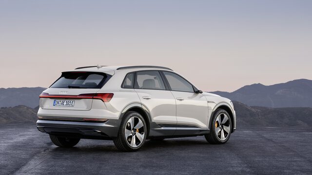 2019 Audi e-tron white rear three-quarter view on hilltop at dusk