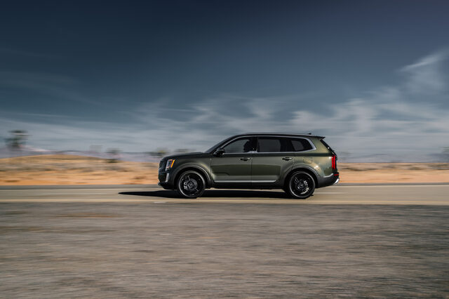 2020 Kia Telluride EX side profile in motion on open desert highway