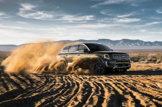 2020 Kia Telluride EX front three-quarter action shot kicking up desert dust