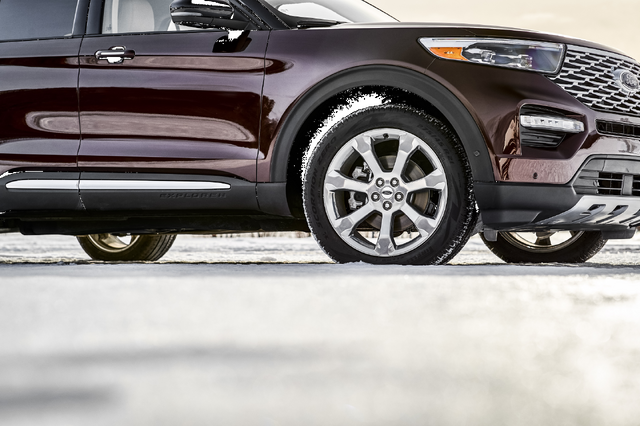 2020 Ford Explorer Platinum low angle front side view showing wheel and body trim on snow