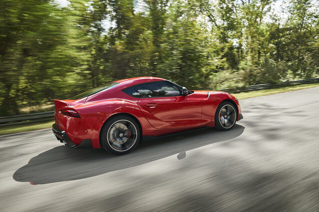2020 Toyota GR Supra red side profile panning shot at speed on track