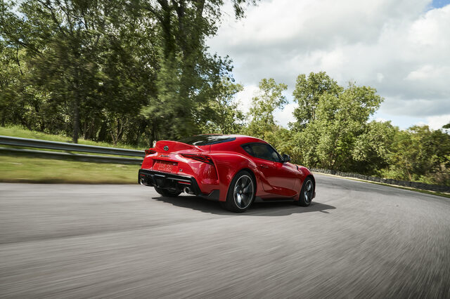 2020 Toyota GR Supra red rear three-quarter curving through sweeping bend
