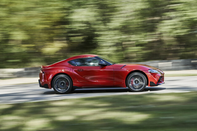 2020 Toyota GR Supra red side profile panning shot moving at speed on track