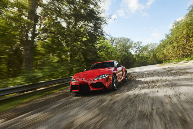 2020 Toyota GR Supra red front three-quarter panning action on sunlit track road