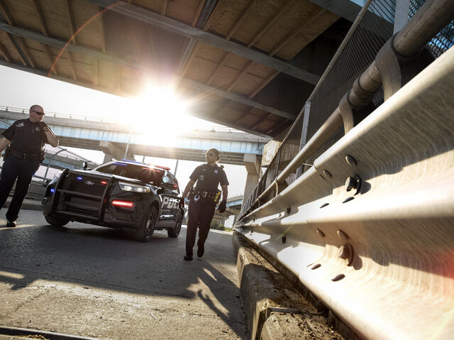 2020 Ford Police Interceptor Utility black with officers under highway overpass