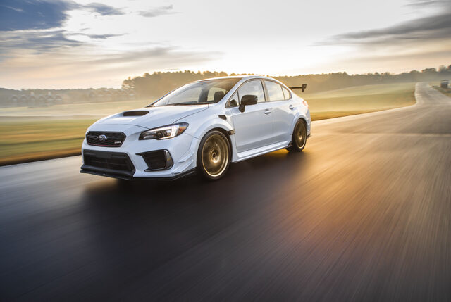 2019 Subaru WRX STi S209, front three-quarter action panning shot on track at sunset