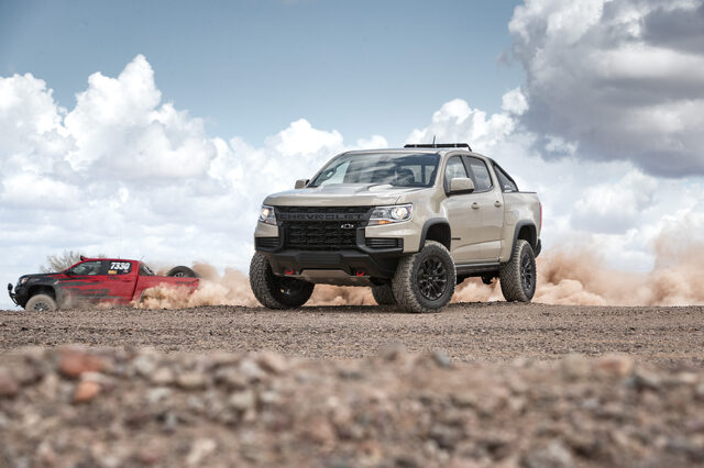 2021 Chevrolet Colorado ZR2 with race truck in background on desert terrain