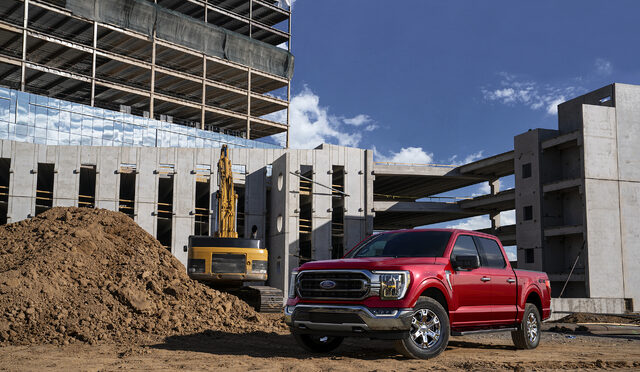 2021 Ford F-150 at snowy construction site with crane loading truck bed