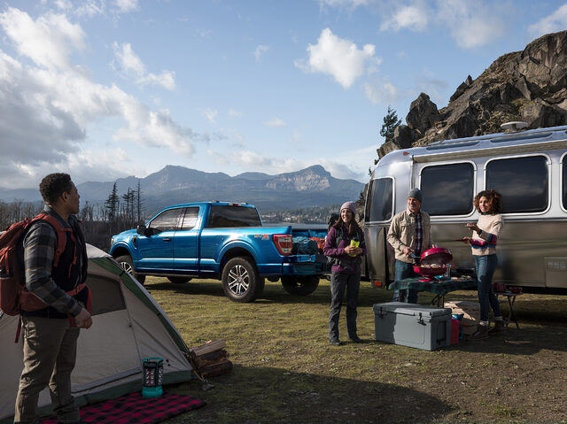 2021 Ford F-150 parked at log cabin at dusk with hikers