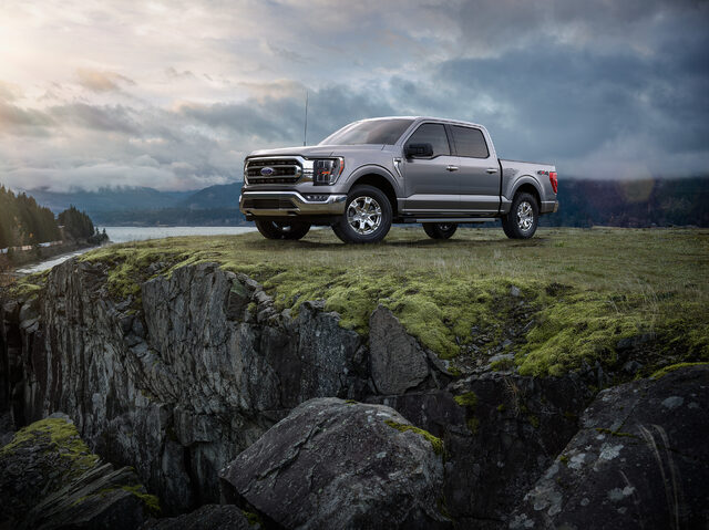 2021 Ford F-150 towing a boat at waterfront launch with bridge backdrop