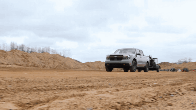 2023 Ford Maverick Tremor towing ATV on dirt road distance shot