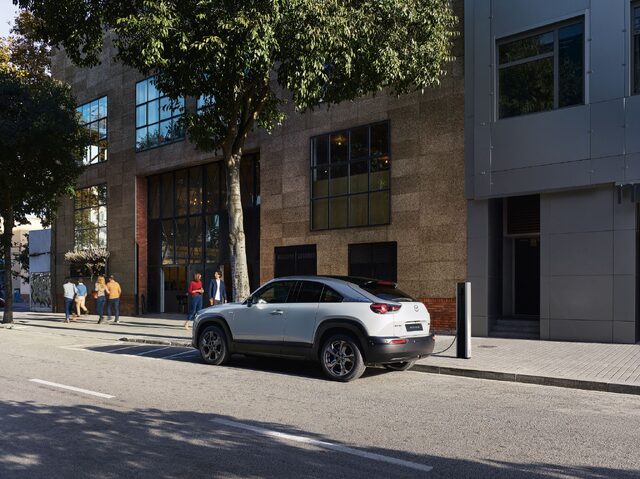 Mazda MX-30 Rear Three-Quarter View Charging on City Street