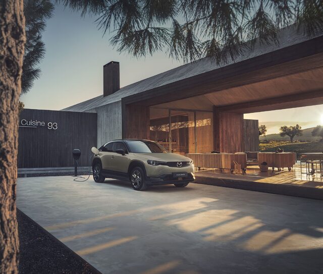 Mazda MX-30 Charging at Modern Home at Sunset
