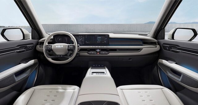 2024 Kia EV9 interior dashboard view showing dual 12.3-inch touchscreen displays, steering wheel, and light gray front cabin