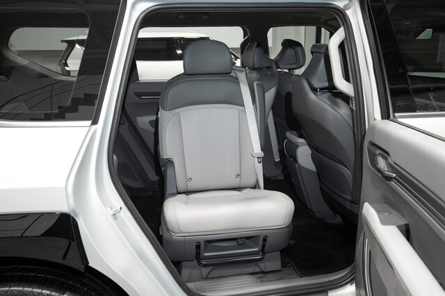 2024 Kia EV9 open door showing an individual second-row captain's chair with two-tone leather and fold-flat capability