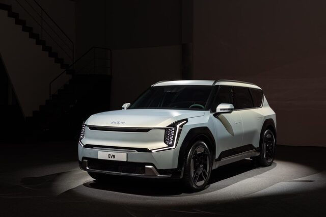 2024 Kia EV9 straight front view on the global reveal stage showing the Digital Tiger Face grille, headlights, and EV9 badge