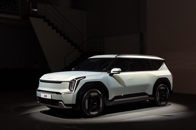 2024 Kia EV9 front three-quarter view on the reveal stage spotlit, showing the polygonal body design and Digital Tiger Face front end