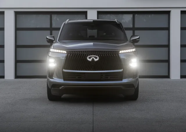 2025 Infiniti QX80 front view at night with headlights on