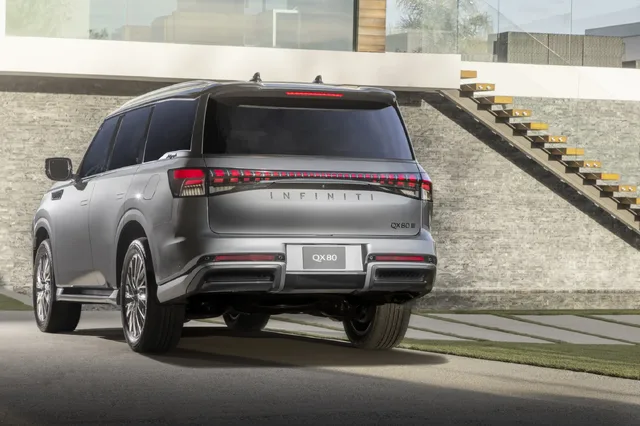 2025 Infiniti QX80 rear three-quarter view at luxury home