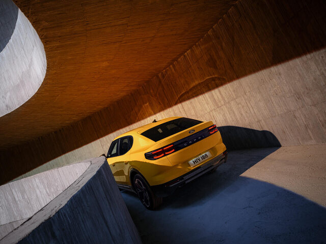 2024 Ford Capri rear three-quarter view in Vivid Yellow inside concrete structure