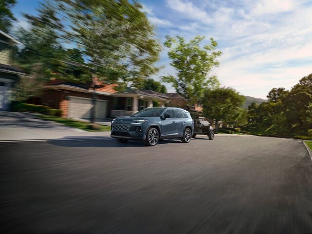 2026 Toyota RAV4 Towing a Trailer in Suburban Neighborhood