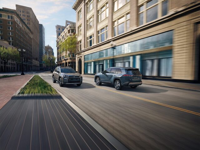 2026 Toyota RAV4 Two Models Driving in Urban Setting