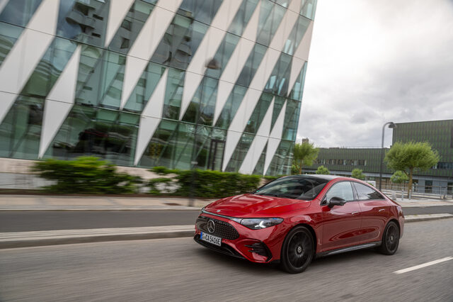 2026 Mercedes-Benz CLA EV Front Three-Quarter View Passing Modern Glass Building