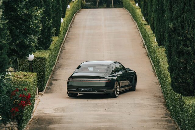 Genesis X Gran Coupe Concept Rear View on Hedge-Lined Garden Path