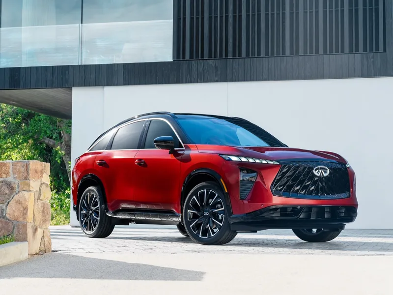 2027 Infiniti QX65 Sport Exterior Front Three-Quarter View Sunfire Red with Black Roof and Running Boards