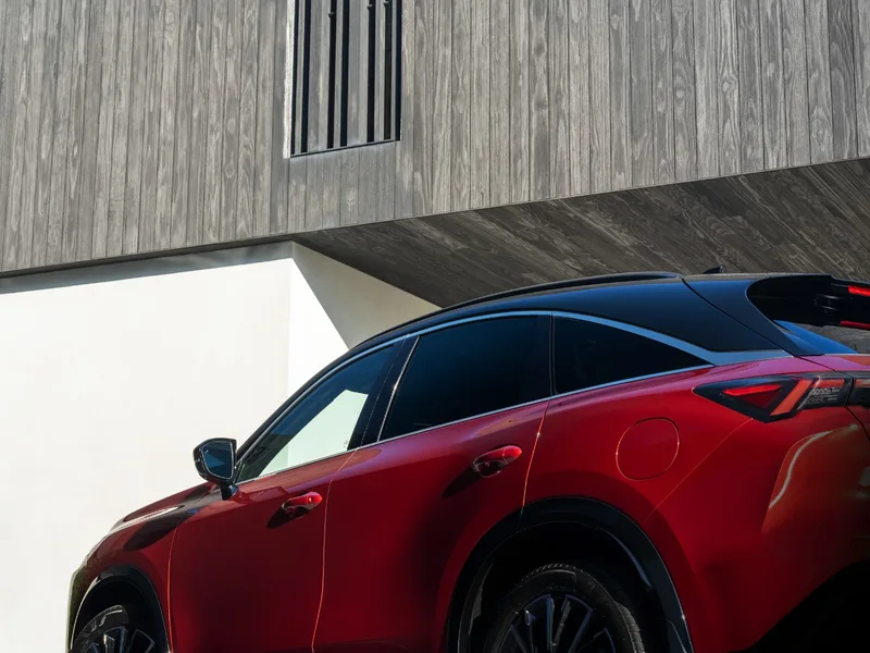 2027 Infiniti QX65 Sport Exterior Rear Three-Quarter View Sunfire Red Showing Fastback Roofline and LED Taillights