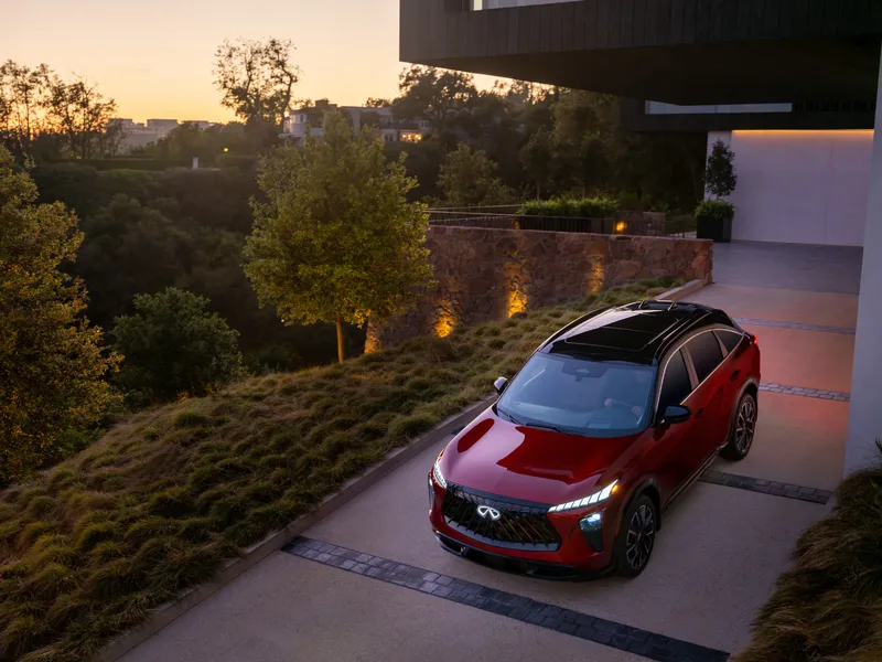 2027 Infiniti QX65 Sport Exterior Overhead Front View at Dusk with Headlights Illuminated Sunfire Red