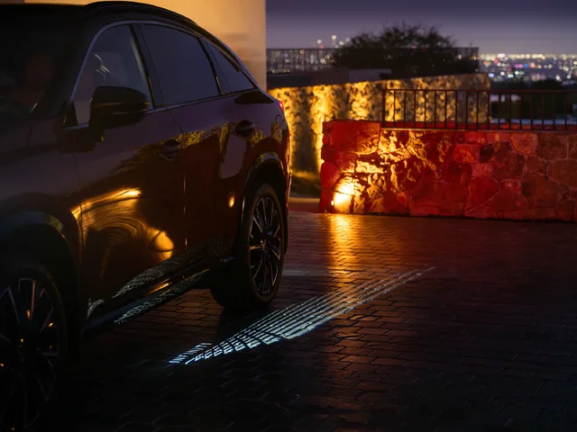 2027 Infiniti QX65 Sport Exterior Nighttime Side View with Door Sill Puddle Light Projected on Cobblestones