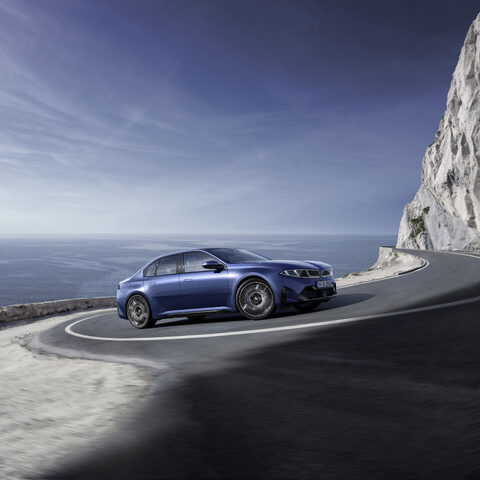 2027 BMW i3 Sedan Sweeping Through a Seaside Switchback