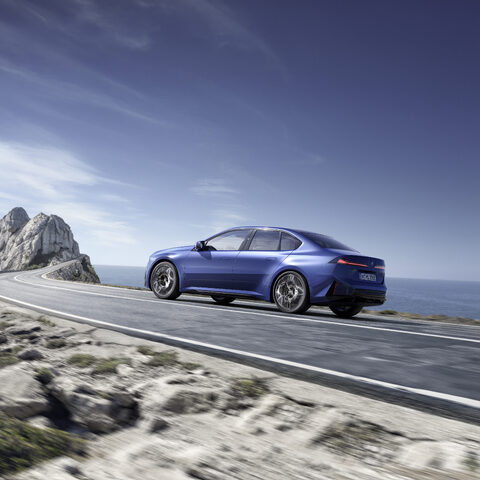 2027 BMW i3 Sedan Rear Three-Quarter Driving Along the Coast