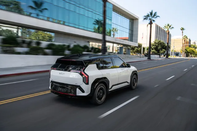 2027 Kia EV3 Rear Three-Quarter, Moving Shot, White Exterior with Red Tail Lighting
